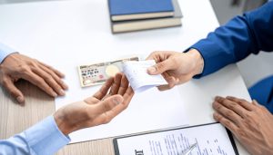 短期借入金の種類や長期借入金との違いを知り、借入金の契約で融資を受ける事業主が金融機関から運転資金や事業資金を調達する様子