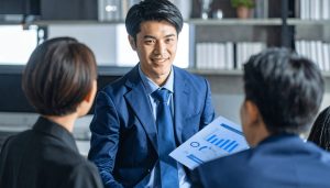 現在の融資の返済計画書を前に、資金繰りの悪化を受け、事業資金の借り換えを真剣に検討する経営者が、より良い条件を模索している様子