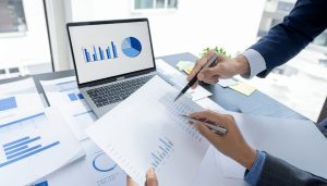 売掛取引のメリット・デメリットをPCや資料で確認し、資金繰りの悪化リスクや与信管理の手間について議論する担当者