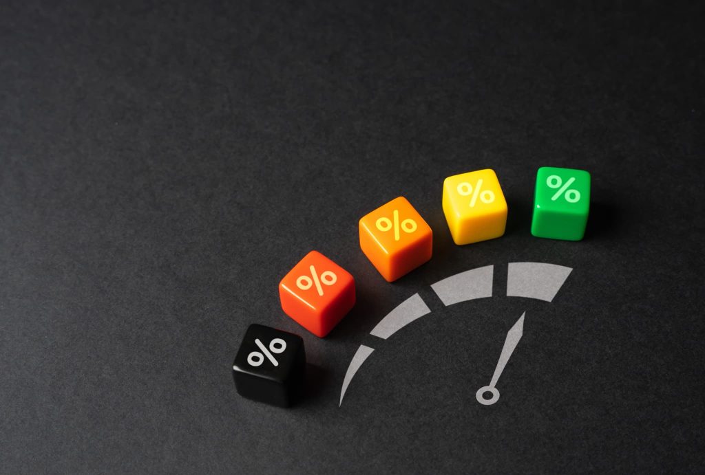 メーター状のデザインに配置されたパーセント記号のブロック。ファクタリングの手数料や金利が相場の範囲内かレベルで示すイメージ