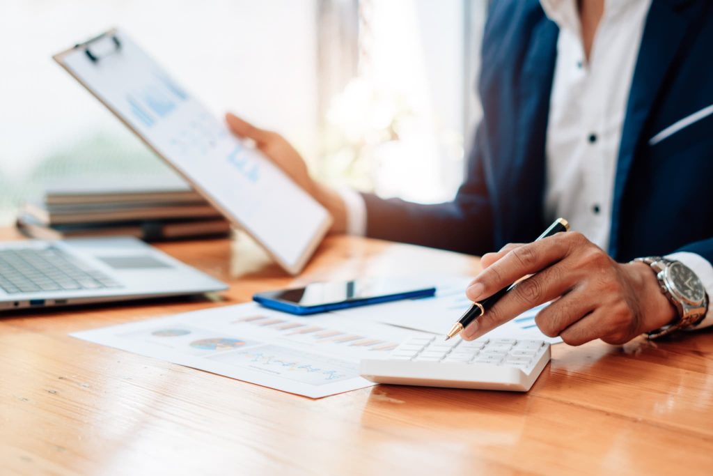 債権とは将来的に現金化される資産であるため回収予定や残高をグラフ資料と電卓で管理している様子