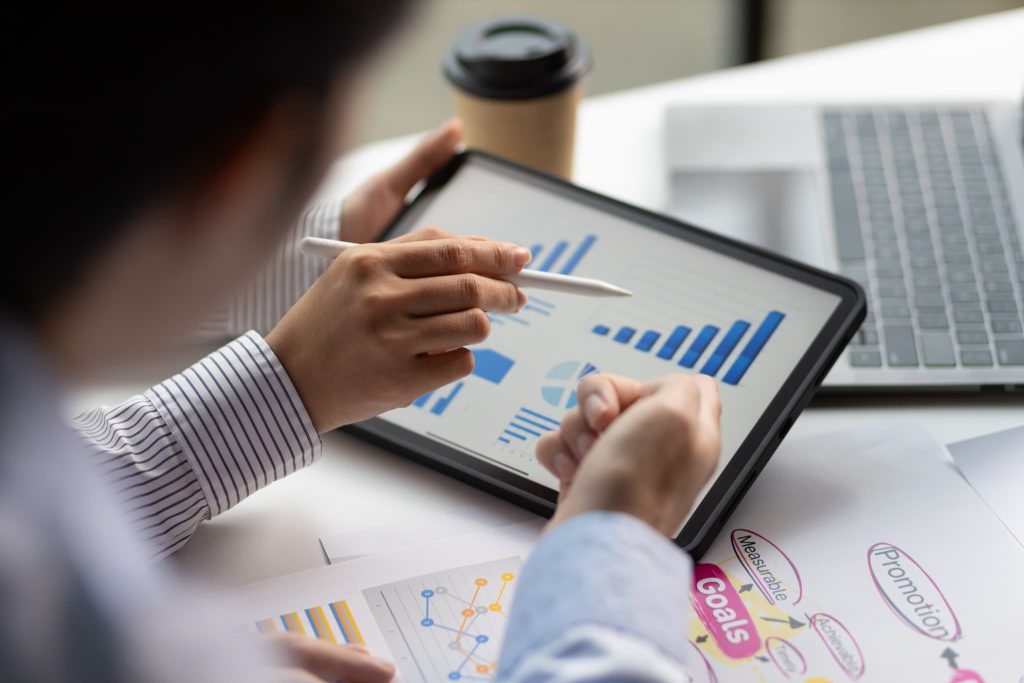 タブレット上の棒グラフをペンで指し示している手元。売掛金とは売上の計上から回収までの期間管理や分析が求められる信用取引の仕組み