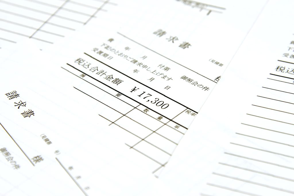 「請求書」と印字された日本語の書類のクローズアップ。追加融資の審査において資金使途を証明するためのエビデンス資料や経費支払いのイメージ
