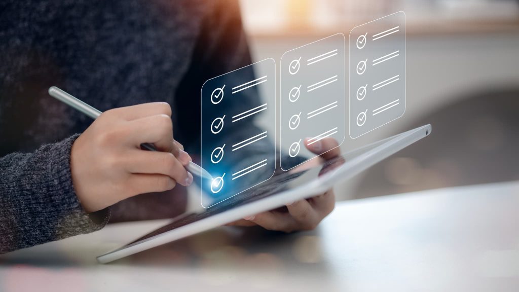 タブレットをペンで操作し空中に浮かぶチェックリストを確認している様子。助成金の受給要件を満たしているか確認したり申請書類の不備を点検している場面