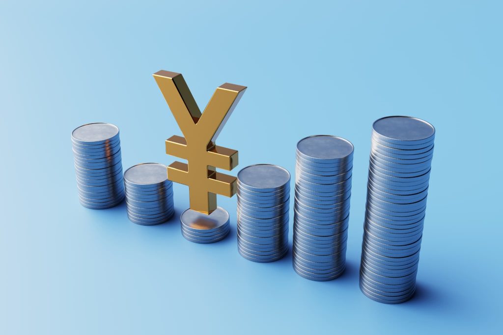 資金調達サービスを活用して資本が増加していく様子を象徴する積み上げられた硬貨と円記号のオブジェ