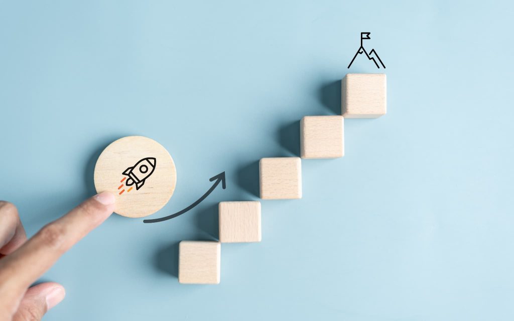 ロケットが描かれた木片を階段状の積み木に沿って押し上げる様子。請求書払いを利用する流れを3ステップで示すイメージ