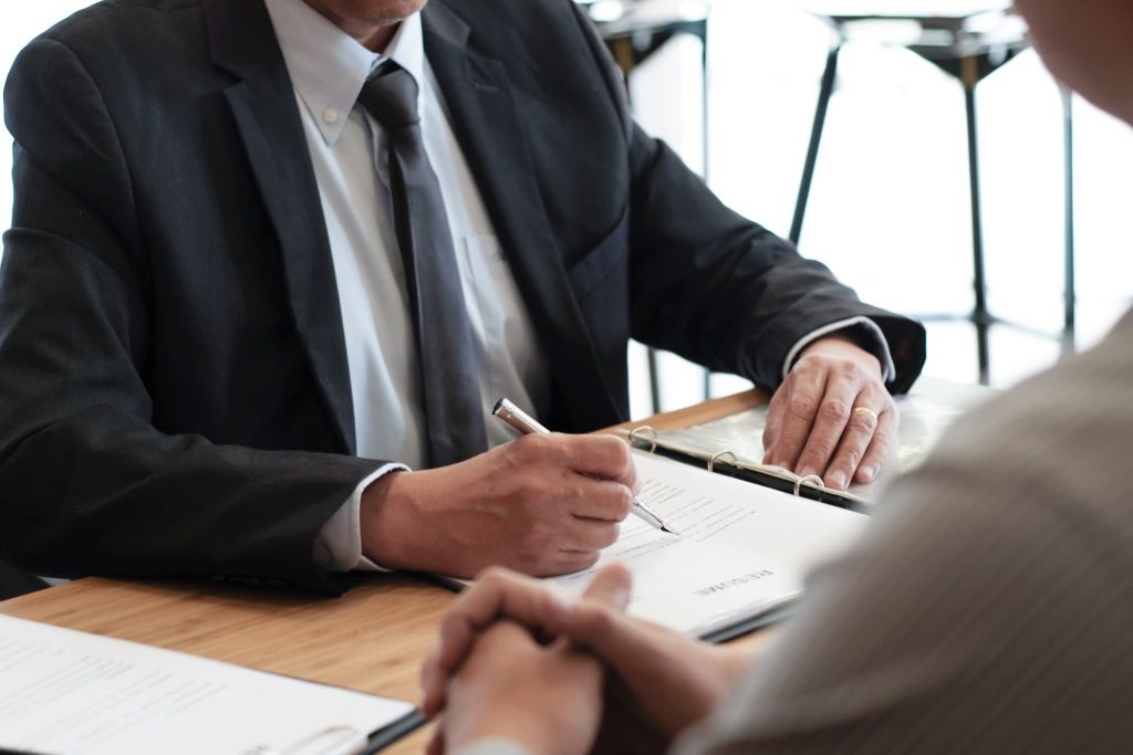 債権とはどのような権利か説明を受けた上で契約書にサインを行い契約を締結しているビジネスマン
