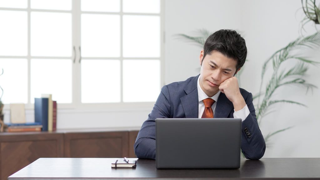 ファクタリングの返済や資金繰りに行き詰まりパソコンの前で頭を抱えて悩んでいる経営者