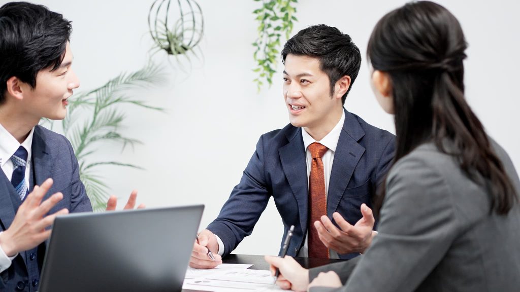 事業拡大に向けた資金調達の戦略について、中小企業のチームメンバーが活発に意見交換を行っているミーティング風景