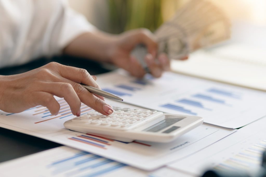 売掛金買取を利用して調達できる現金の額や手数料を電卓と書類を使って計算している様子