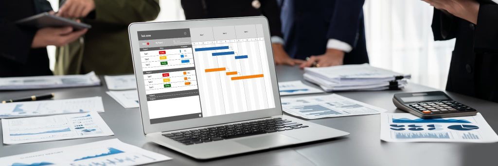 経営の業務効率化と固定費削減のためにパソコンで工程表を管理し生産性を向上させているオフィスの様子