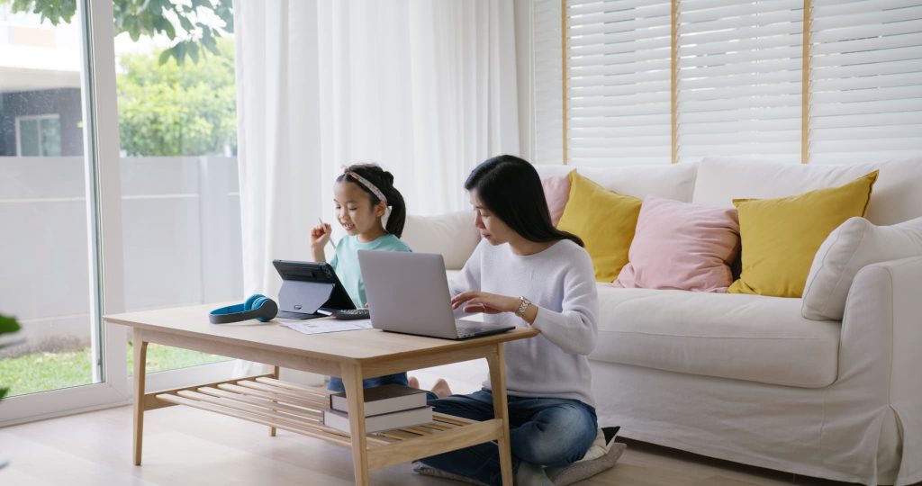 子育てと仕事を両立するフリーランスや個人事業主が補助金と助成金の違いをパソコンで調べている様子