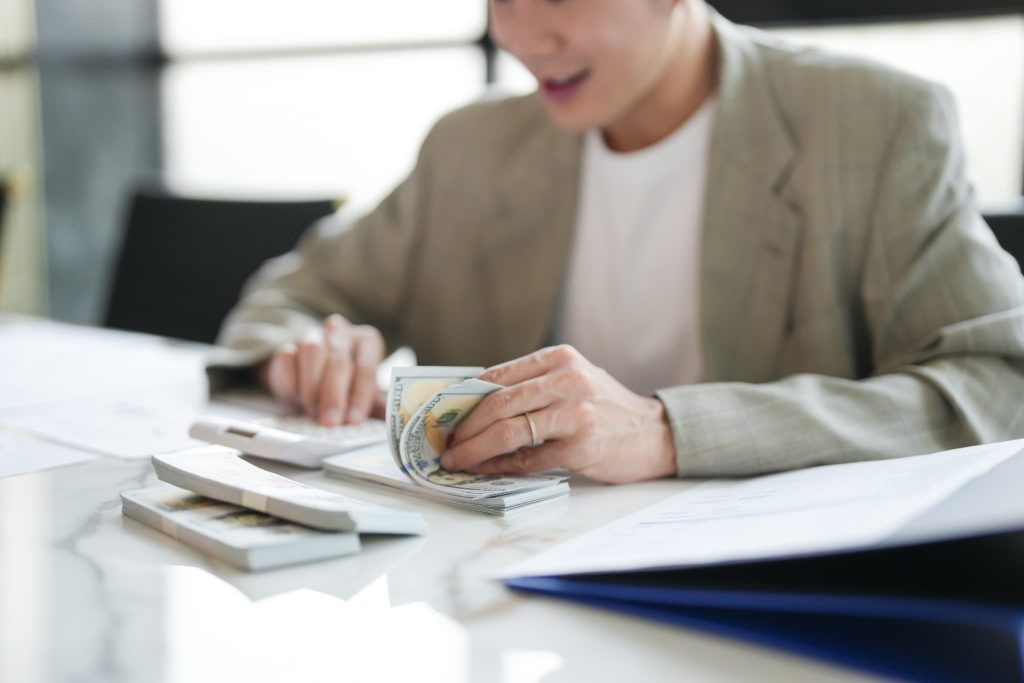 立て替え払いとは一時的に現金を確保する手段であるため手元の資金と電卓を使って計算している様子