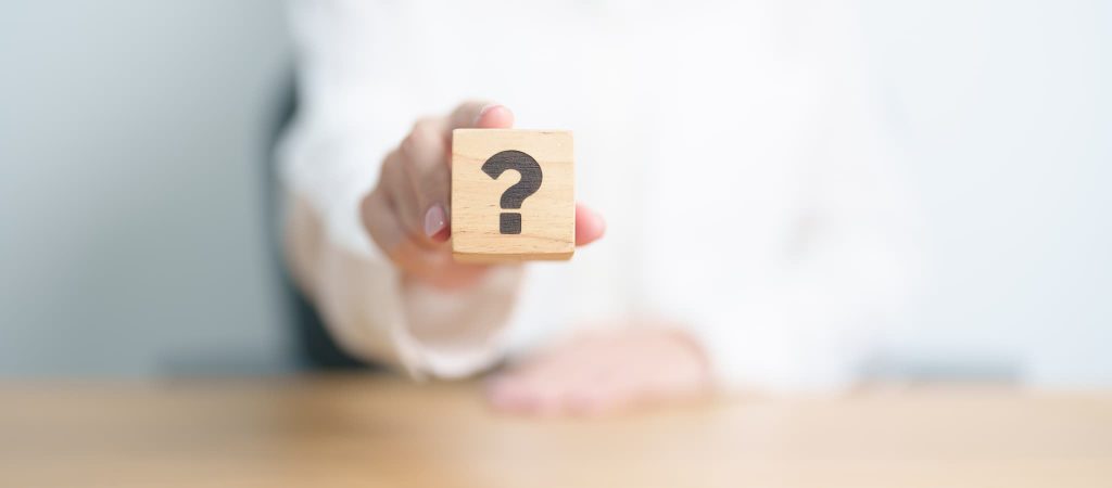 2社間ファクタリングと3社間ファクタリングの違いや選び方に関する疑問を表すクエスチョンマークの積み木