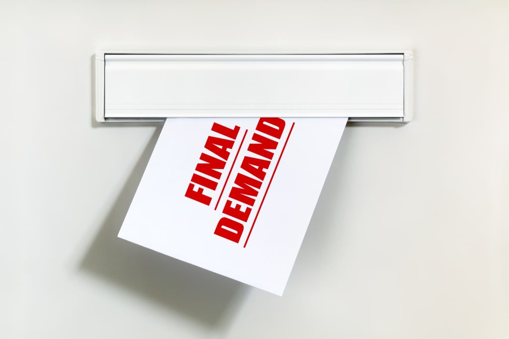 支払いの最終通告であることを強調するFINAL DEMANDと印字された督促状がポストに入っている様子