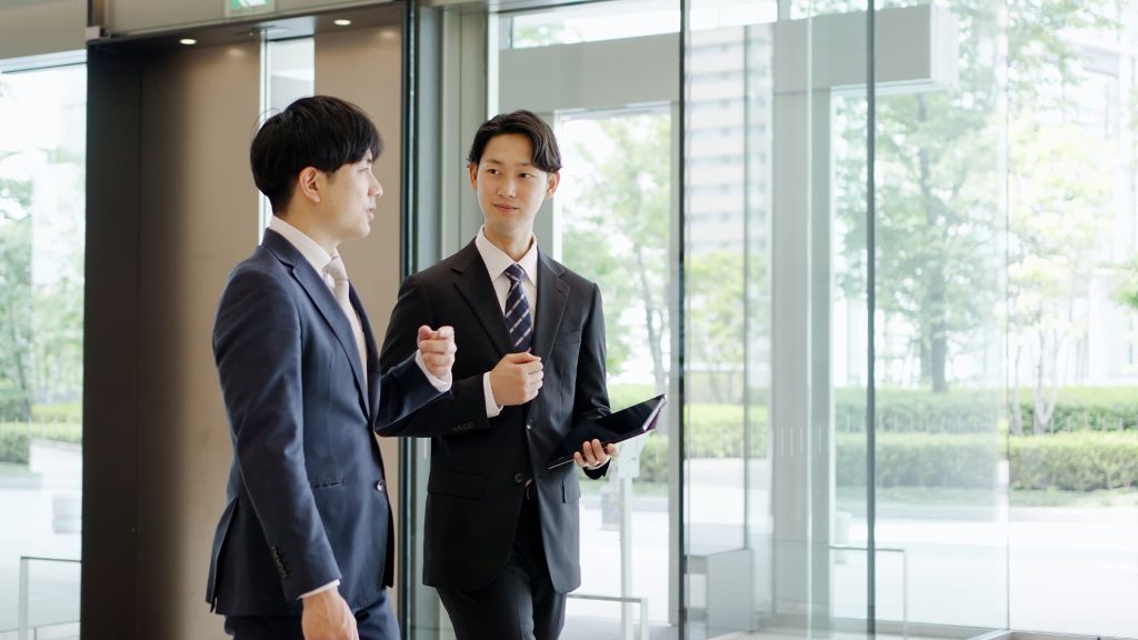 手形割引とはどのような審査が必要か銀行の担当者と歩きながら打ち合わせをしているビジネスマン