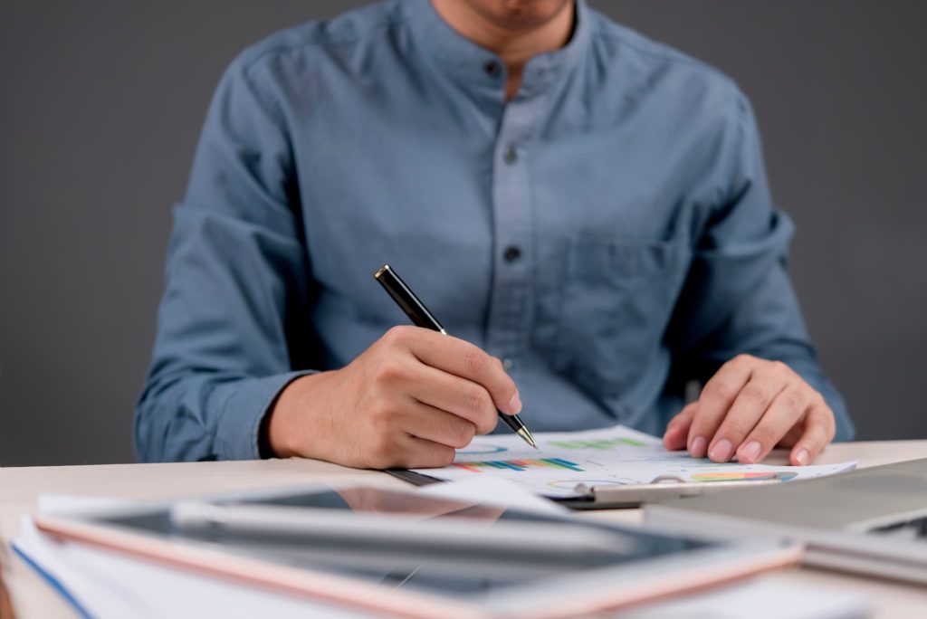 立て替え払いとは資金繰り改善に役立つかを判断するために資料を確認し検討を行っている手元