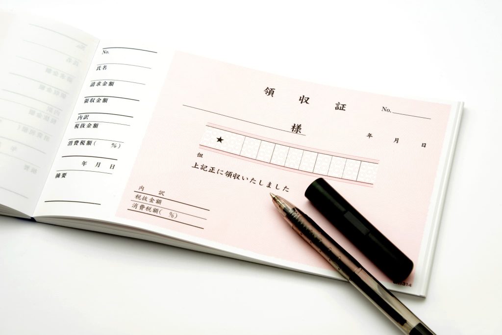 立て替え払いとは後払いの仕組みであるため領収証や請求書の管理が重要であることを示す筆記用具と用紙