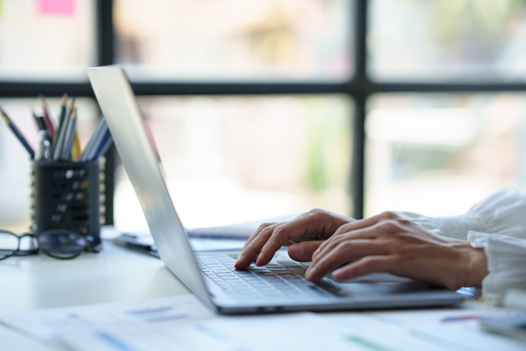 ファクタリングはやばいサービスではないかインターネットで評判や口コミを検索して調査しているノートパソコン上の手元