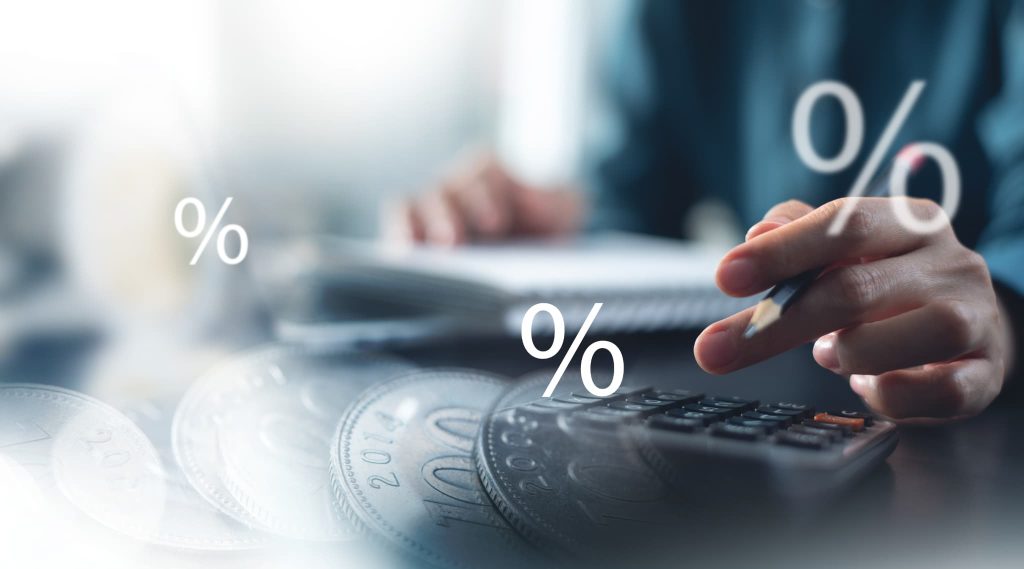 営業キャッシュフローの比率を算出するため、電卓や小銭を前にしてパーセント記号が浮かぶ中で計算を行う様子