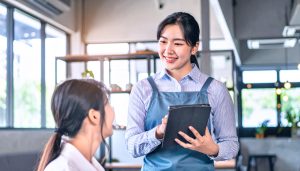 運転資金が必要な個人事業主が、負債を増やさずスムーズに資金調達できるファクタリングを活用し、信頼性の高い売掛金を現金化してカフェなどの店舗経営を安定させている様子