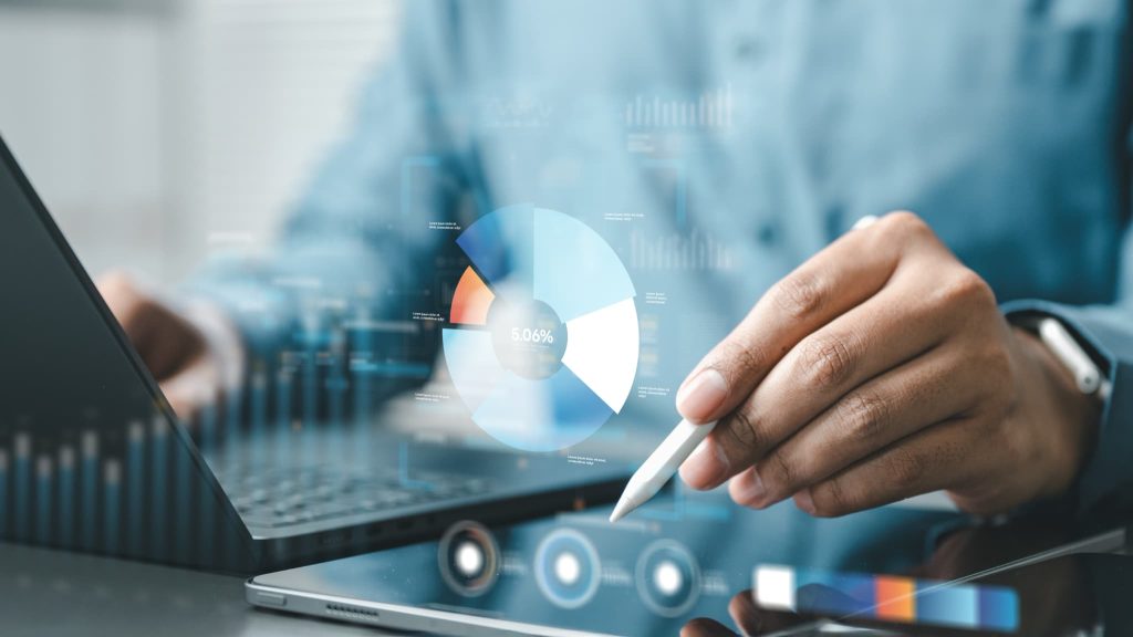 タブレット端末で円グラフを指し示し財務状況を分析する様子。資金繰りが苦しい原因を特定し経営改善を図るためのデータ確認