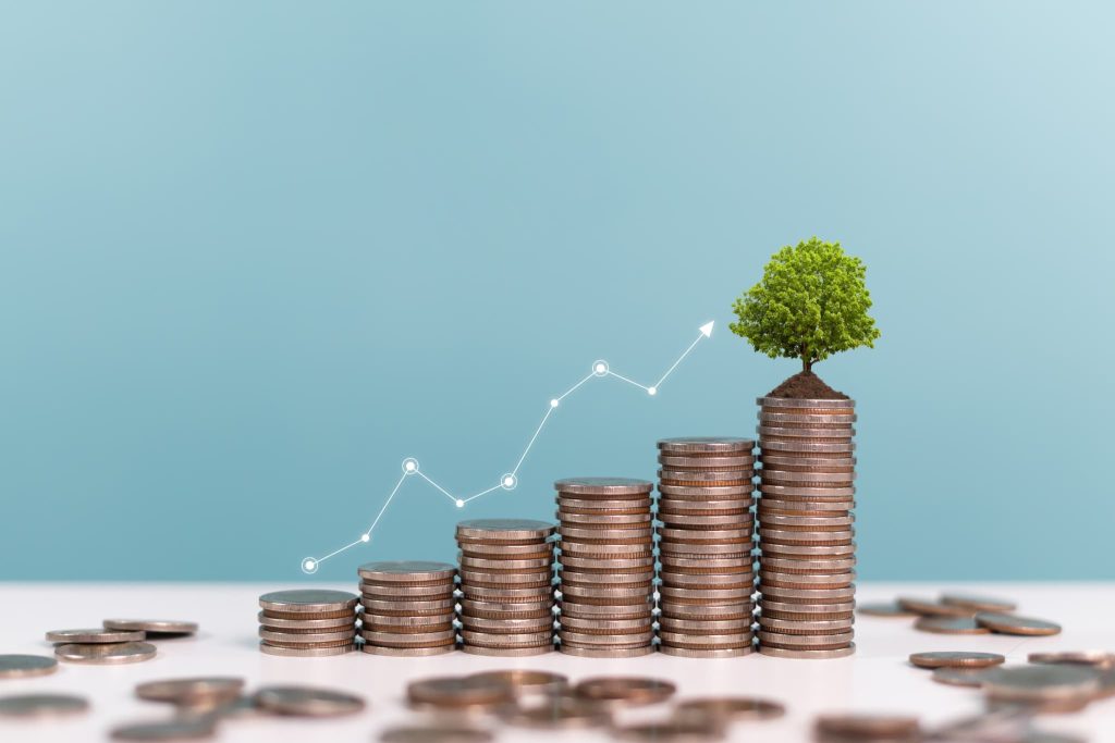 積み上げられたコインの山の上に小さな木が育ち、右肩上がりの折れ線グラフが重なる。資金繰りとは企業の将来性を支える土台であることを示す図解
