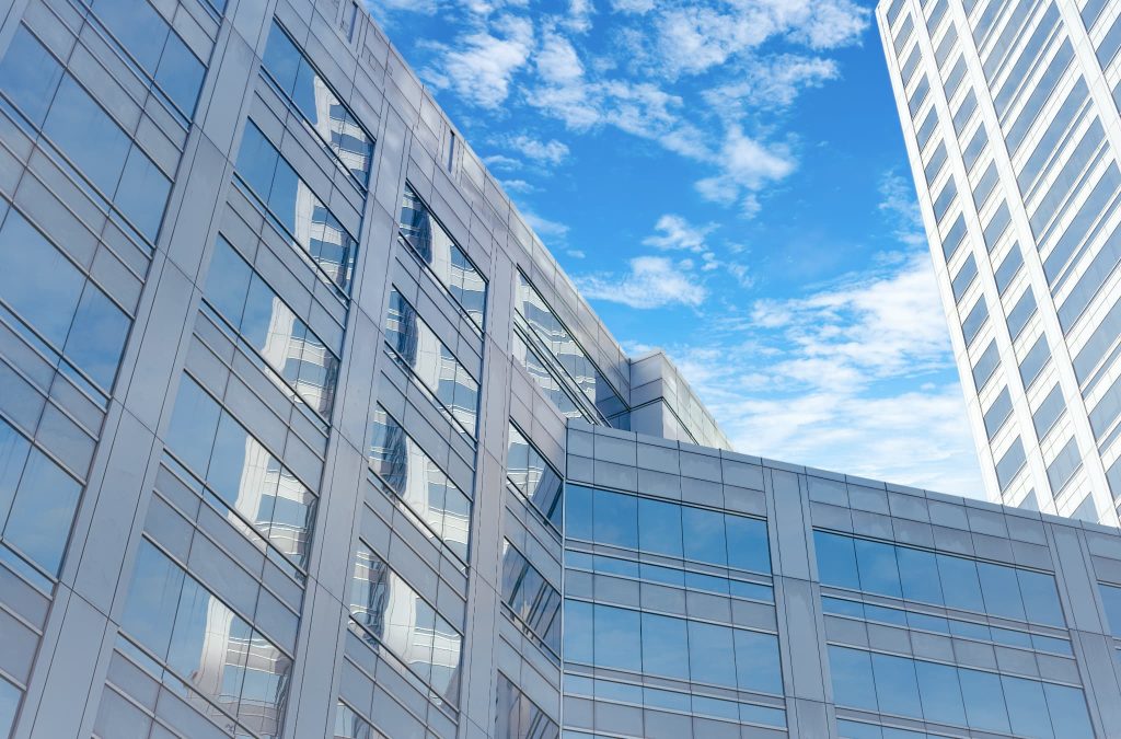 青空の下にそびえ立つ近代的なオフィスビルの外観。運転資金の融資を依頼する銀行や金融機関、企業の拠点となるビルを象徴するイメージ