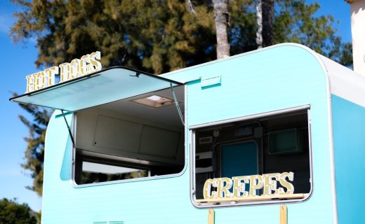 キッチンカー開業の6ステップを解説する記事のメイン画像。青と白のレトロでおしゃれなキッチンカーが、ホットドッグとクレープを提供している様子