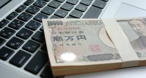 パソコンの上に置いてある開業資金のイメージ