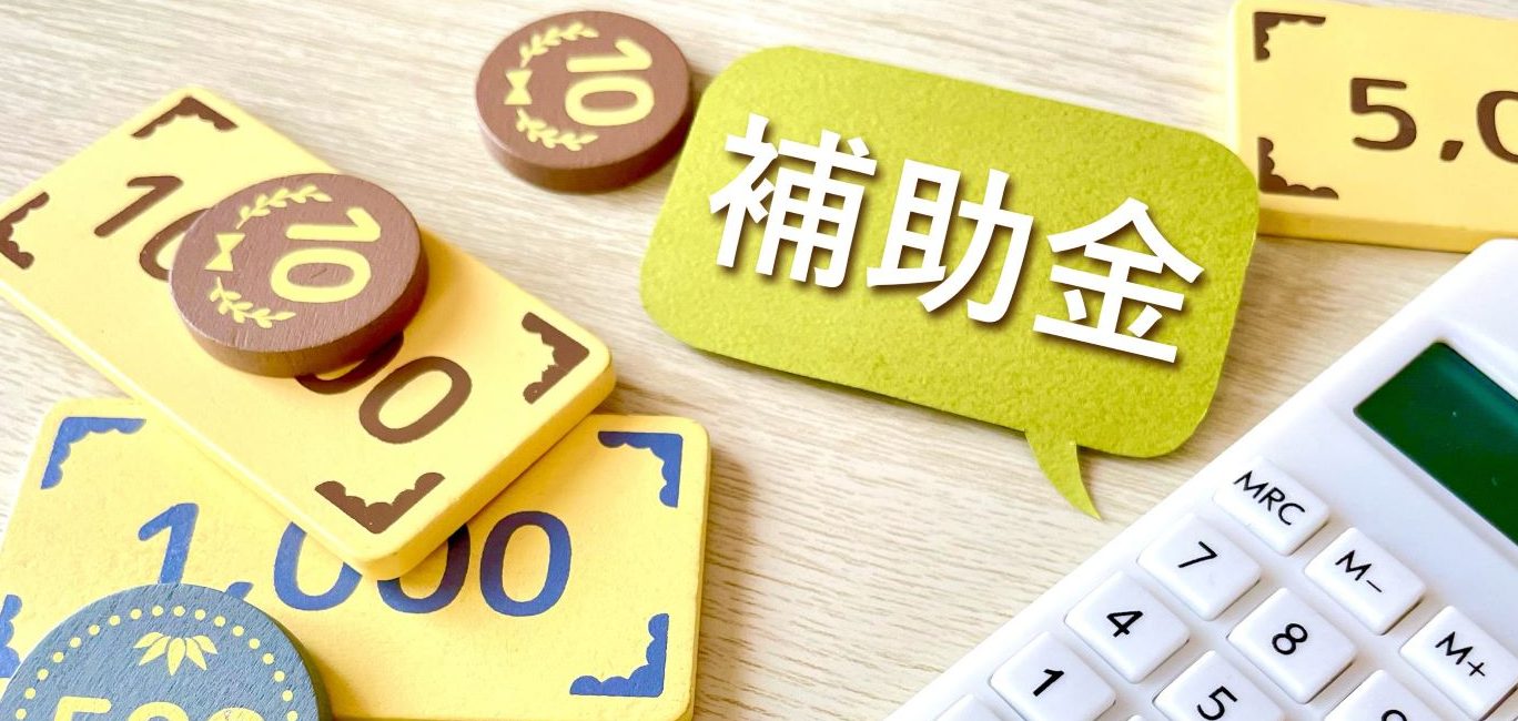個人事業主が活用できる補助金制度のイメージ:「補助金」の吹き出しとお金、電卓