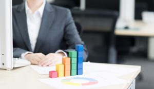 リスティング広告のインハウス化による成果改善をイメージした画像。デスクの上で、カラフルな積み木が右肩上がりのグラフを形作っている