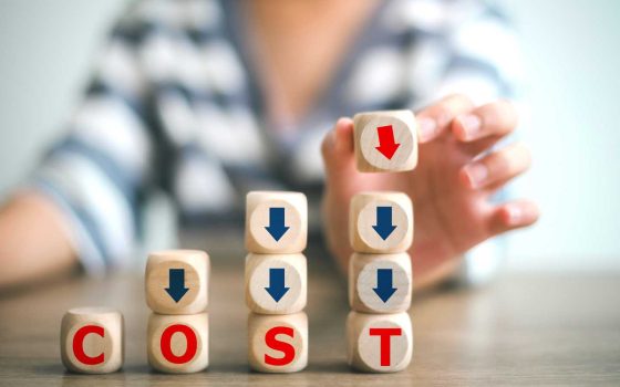 リスティング広告の費用対効果を高めるコツを解説する記事のメイン画像。COSTと書かれた積み木と下向きの矢印でコスト削減を表現