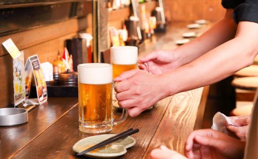 居酒屋のカウンターでビールを提供しているイメージ