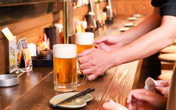 居酒屋のカウンターでビールを提供しているイメージ