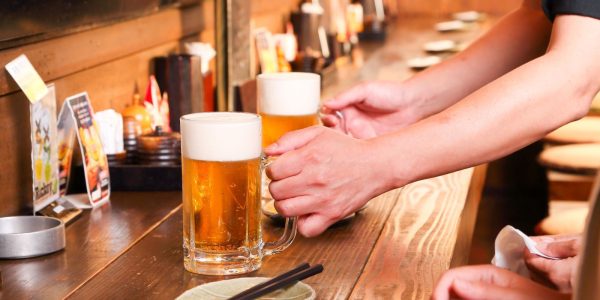 居酒屋のカウンターでビールを提供しているイメージ