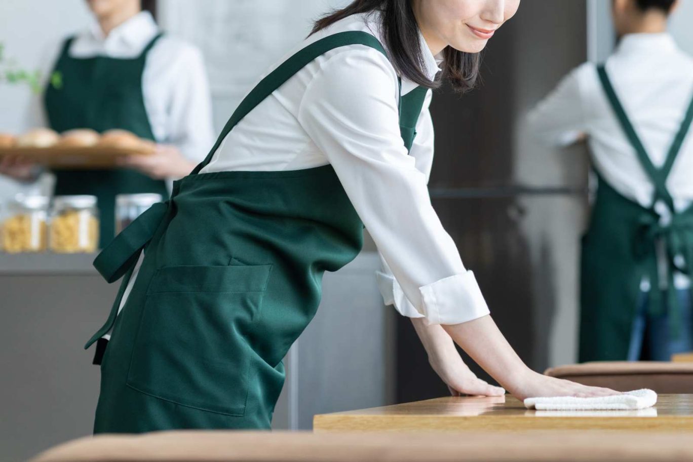 アルバイト・パートの有給休暇のルールを解説する記事のメイン画像。飲食店の店内で、エプロンを付けたスタッフが清掃や配膳などをしている