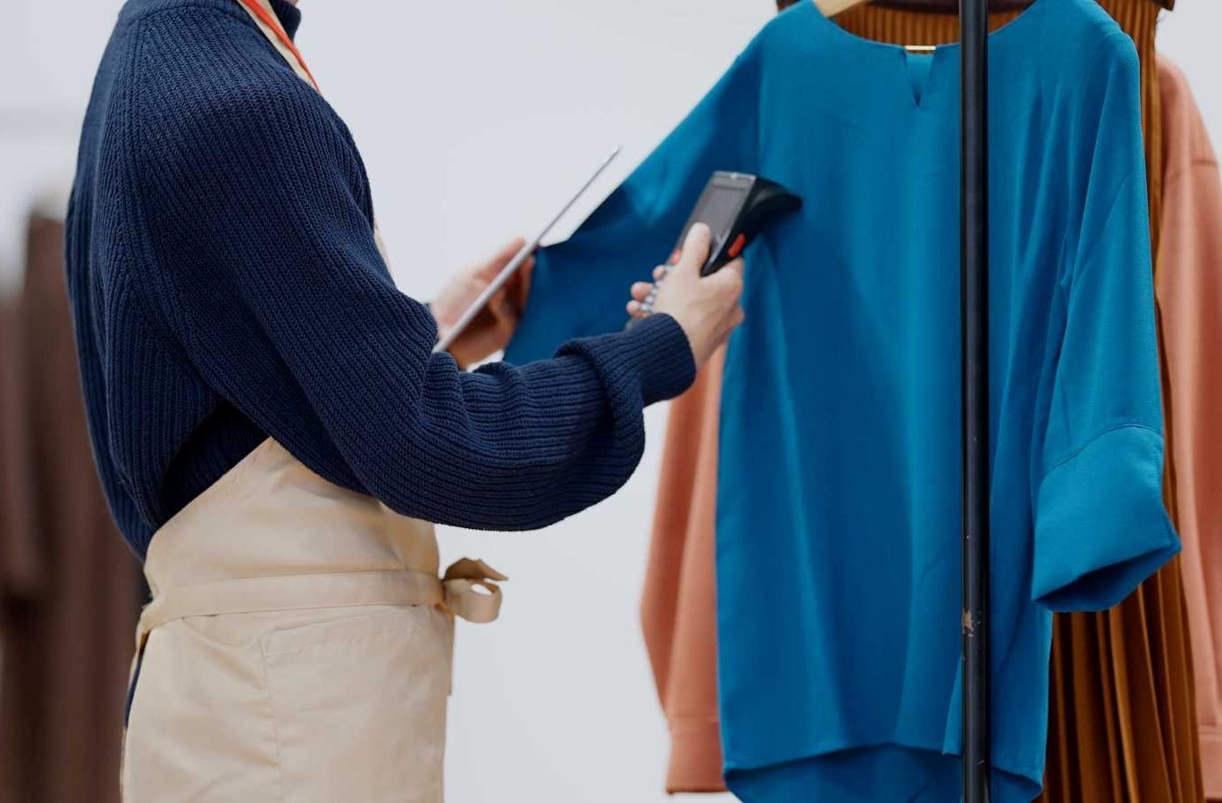 在庫管理の方法を解説する記事のメイン画像。アパレル店員がタブレットとバーコードリーダーを使い、洋服の在庫を管理している様子