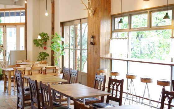 飲食店の物件選びをテーマにした記事のイメージ写真。ナチュラルなインテリアや大きな窓が特徴的な明るいカフェの店内