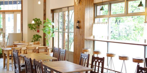 飲食店の物件選びをテーマにした記事のイメージ写真。ナチュラルなインテリアや大きな窓が特徴的な明るいカフェの店内