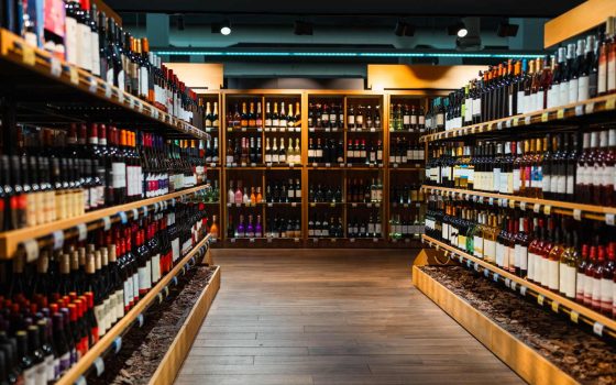 酒屋さん（酒販店）の開業方法を解説する記事のメイン画像。木製の棚にワインなどのお酒がずらりと並ぶ店内の様子