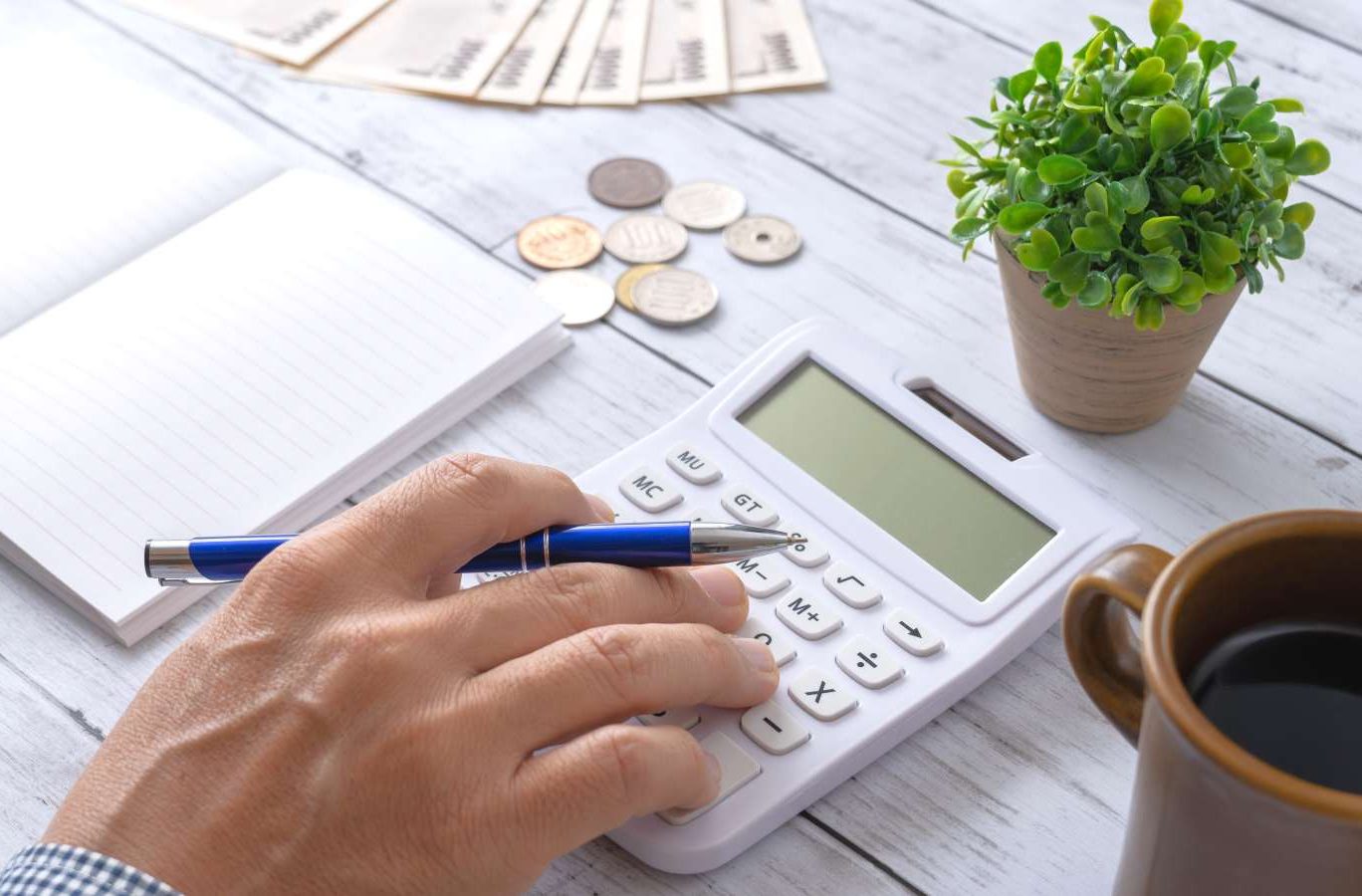 記事のメイン画像：テーブルの上に置いてある電卓で開業資金を計算している様子