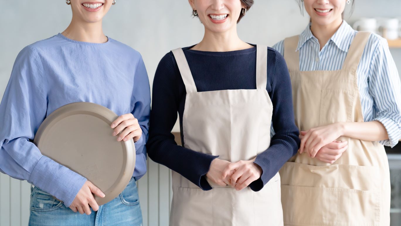 写真：飲食店で笑顔で働く3人の女性スタッフ