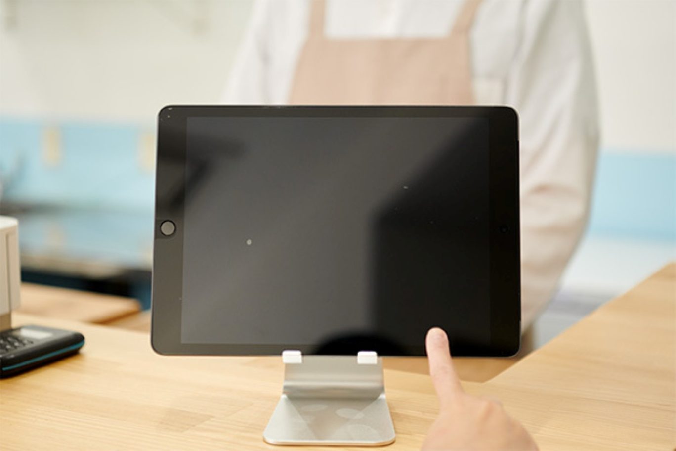 メイン画像：スタンドに設置されたタブレット型のスマートレジ『Airレジ』を操作している様子