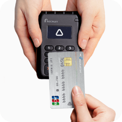 クレジットカードとカードリーダーでタッチ決済する画像